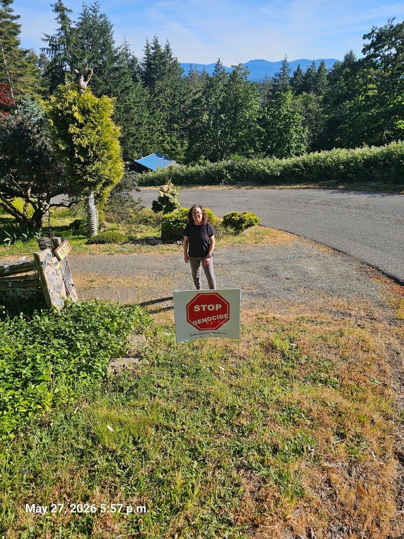 Anna with her Stop Genocide sign on Garland Road, Gabriola