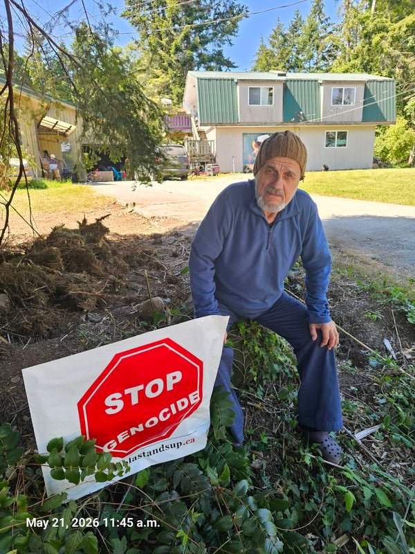 George with his Stop Genocide sign on Queegqueeg Road, Gabriola