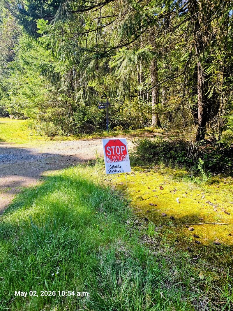 Janina and Jovan with their Stop Genocide sign on Dirkson Road, Gabriola