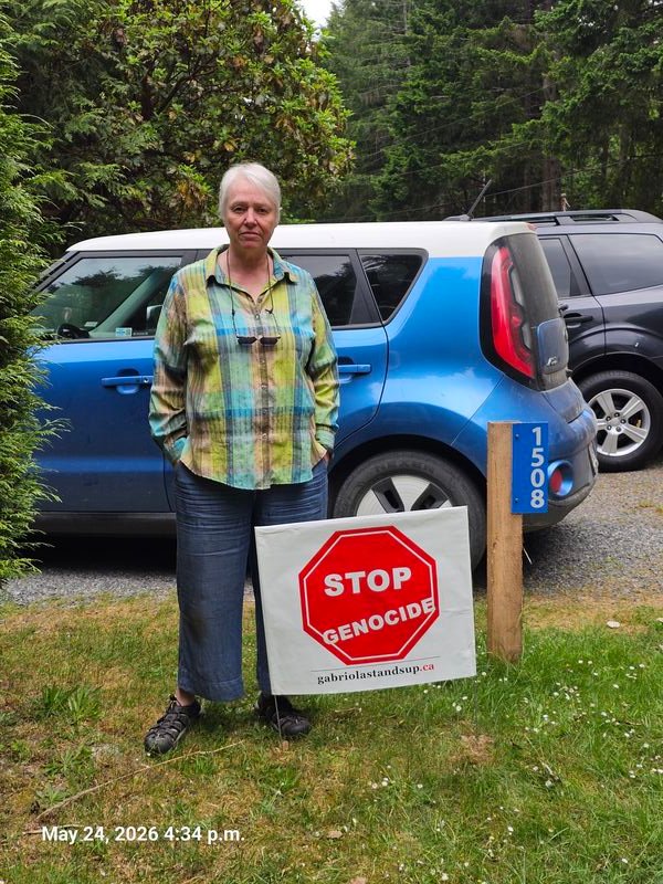 Jen with her Stop Genocide sign on Wild Cherry Terrace, Gabriola
