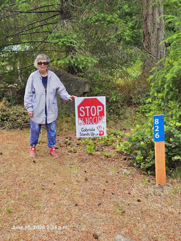 MJ with her Stop Genocide sign on Valli Place, Gabriola