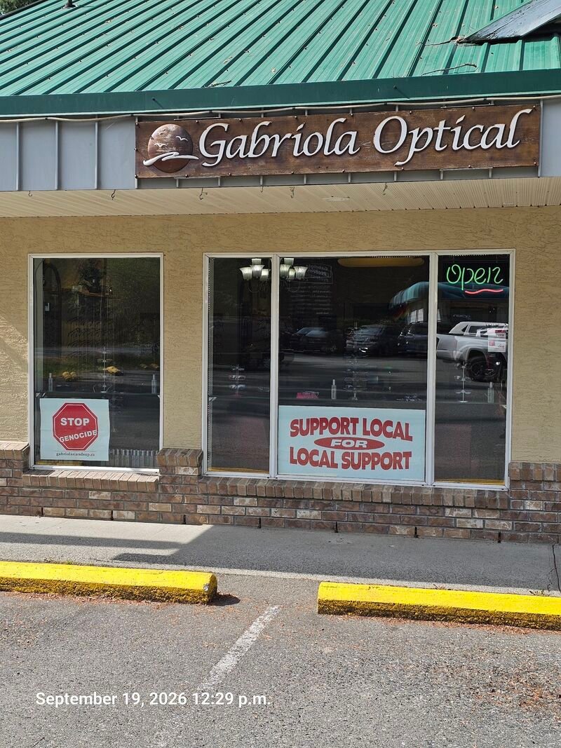 Stop Genocide sign in the window of Gabriola Optical, Village Plaza - sign #121
