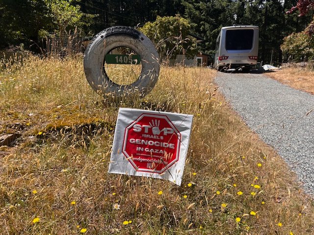 Tene's Stop Genocide sign on Wild Rose Drive, Gabriola
