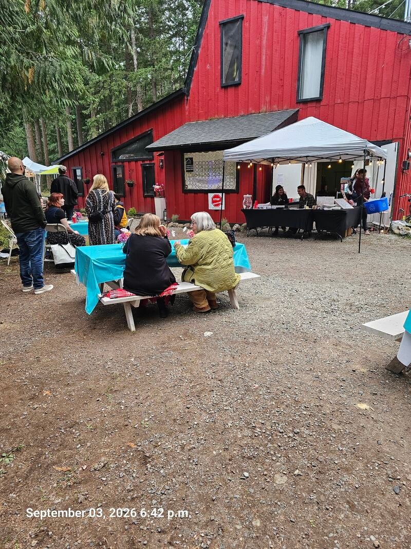 Gabriola Theatre Festival crowd with STOP GENOCIDE sign visible on the theatre