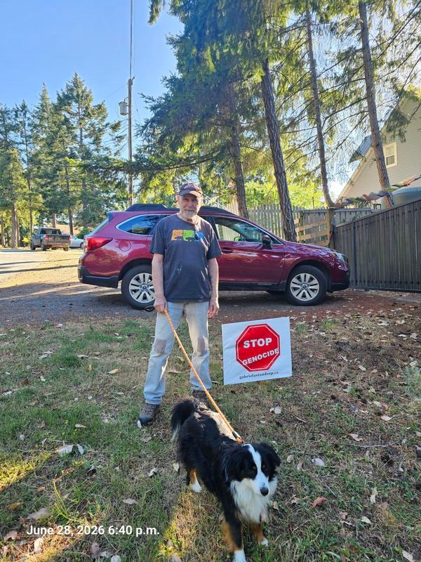 Tim with his Stop Genocide sign on McGillvary Street, Gabriola